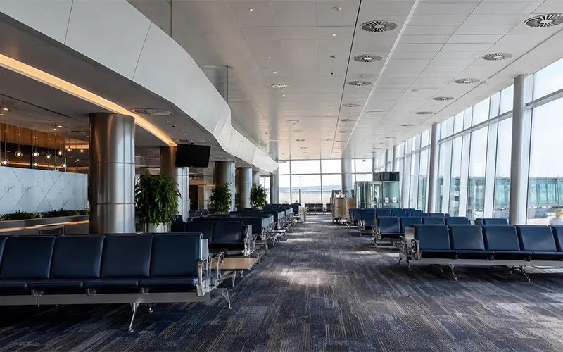 Area di attesa aeroportuale con diffusori HVAC a soffitto per la distribuzione dell’aria.