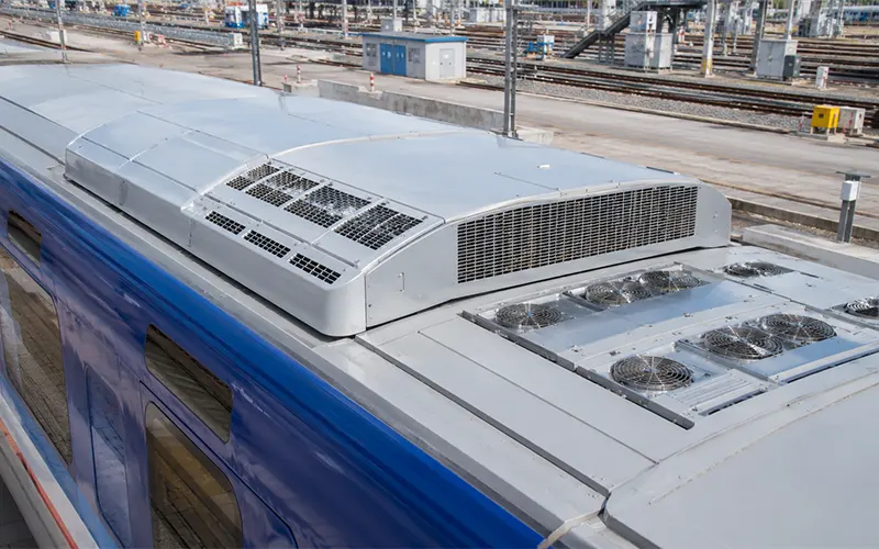 Sistema HVAC montato sul tetto di una carrozza ferroviaria moderna, con prese d’aria e ventilatori per la gestione del flusso d’aria.