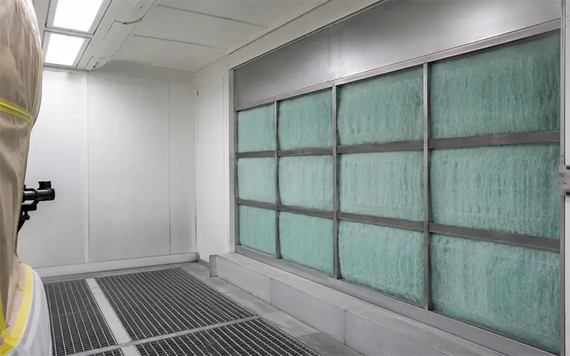 Filtro paint arrestor in fibra di vetro installato nella sezione di estrazione di una cabina di verniciatura.