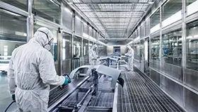Operatore in una cabina di verniciatura durante un processo di rivestimento industriale