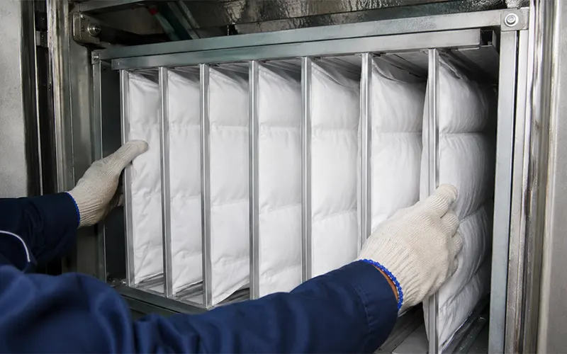 Installazione di filtri a tasche in un sistema HVAC per aumentare la superficie filtrante e gestire la velocità frontale del filtro.